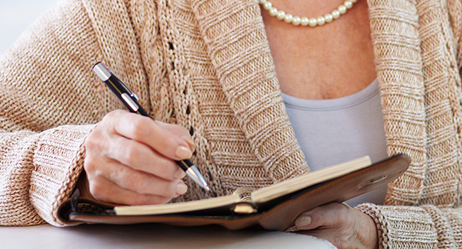 Mujer anotando en una agenda.