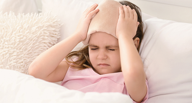 Ni&ntilde;a acostada con dolor de cabeza.